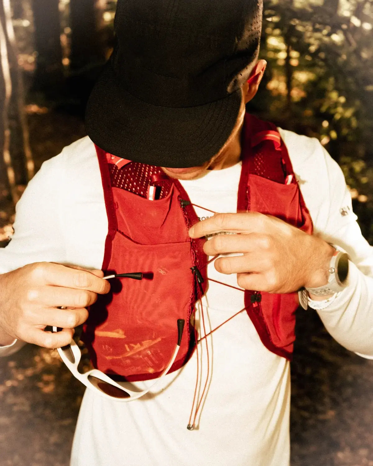 Runner adjusting a red vest with the frame clipped on